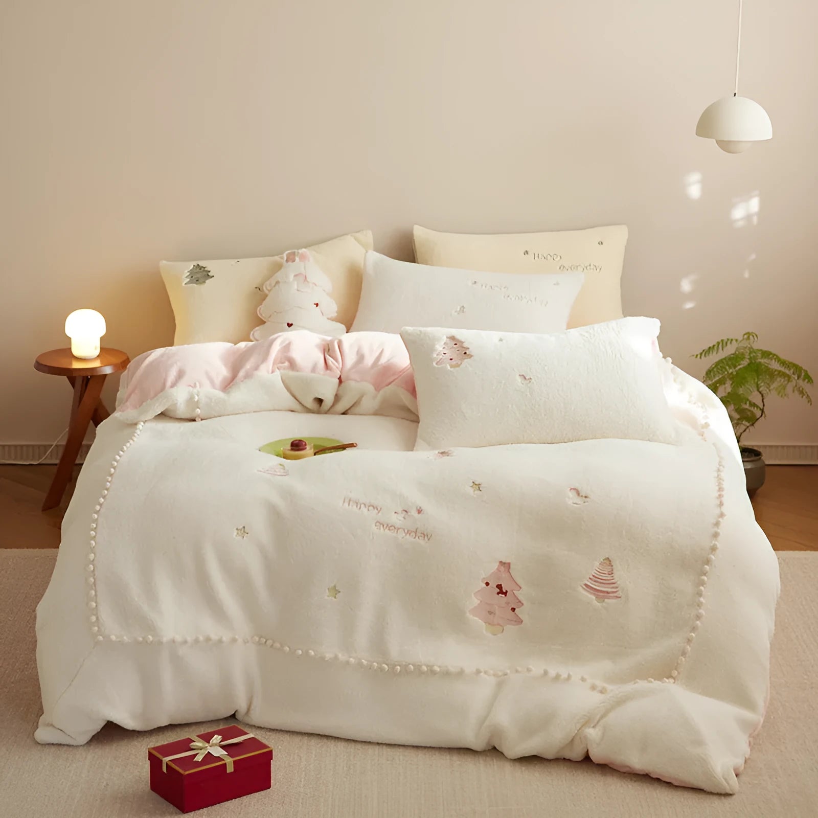 Milk fibre winter bedding four-piece set with green Christmas tree pattern on a bed.