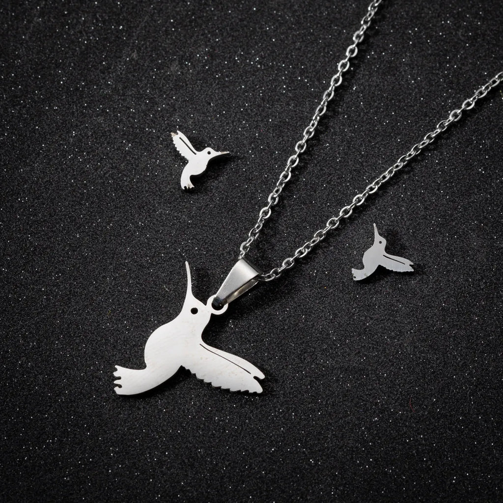 Cute little animal stainless steel jewellery set with bird motif necklace and earrings in gold colour on a white background
