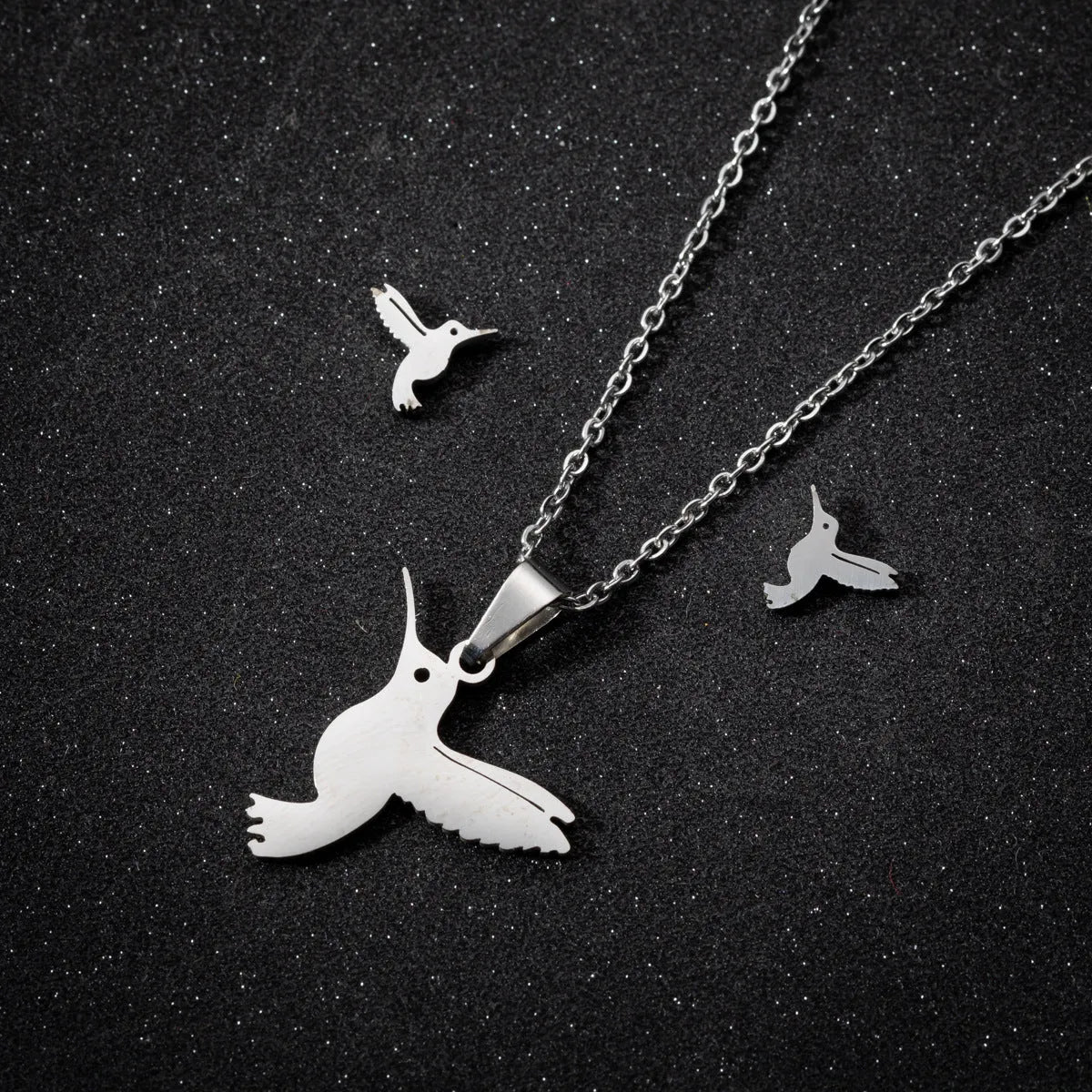 Cute little animal stainless steel jewellery set with bird motif necklace and earrings in gold colour on a white background