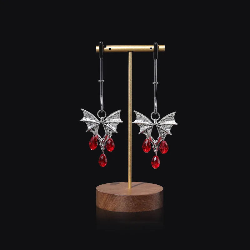 Silver alloy bat-themed nipple clamp with adjustable pressure and a red ruby decorative clip.