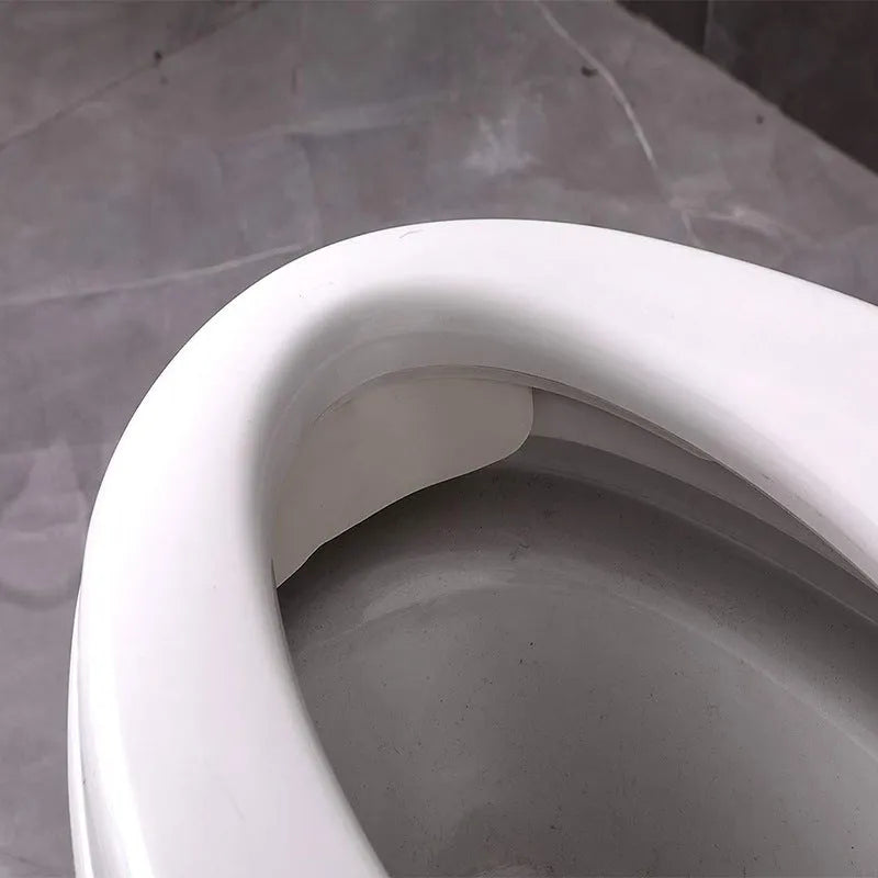 White PVC urine blocking board for children's toilet training placed on standard toilet seat