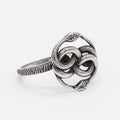 Close-up of a titanium steel double snake ring with a retro design on a hand, showing the intricate intertwined serpent detail.