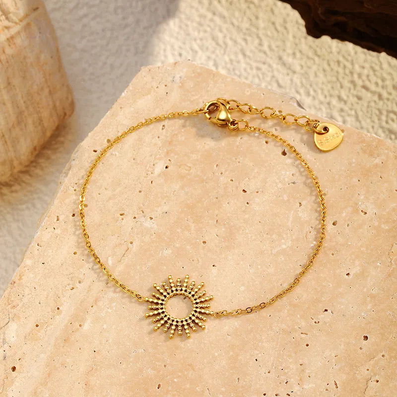 Gold geometric chain necklace and bracelet set for women on a plain background.