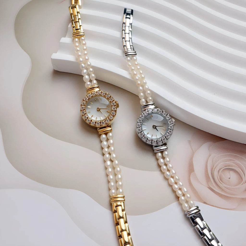Women's light gold bracelet watch with a freshwater pearl charm and round mineral glass dial.