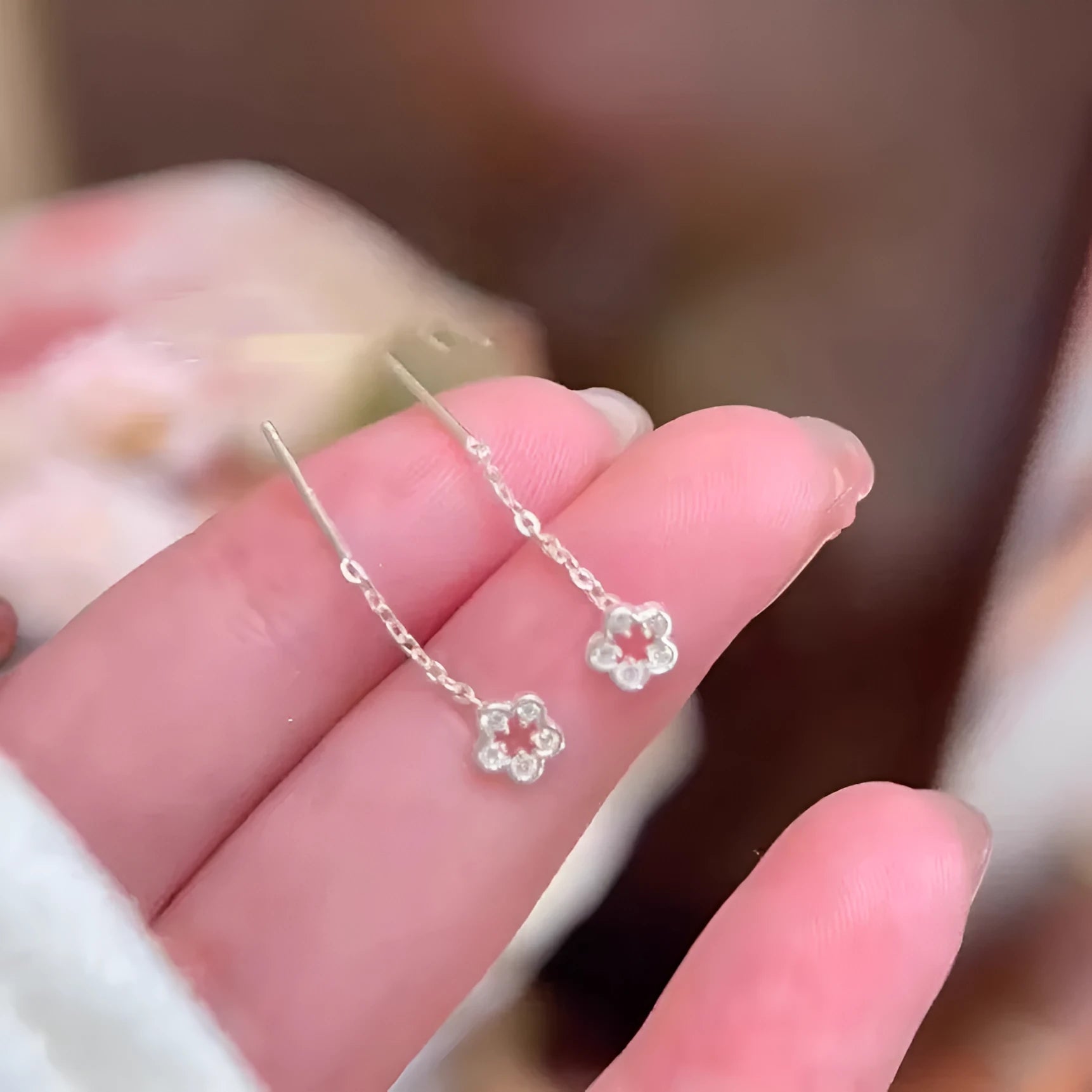 Sterling silver hollow flower drop earrings with needle posts and petal detailing