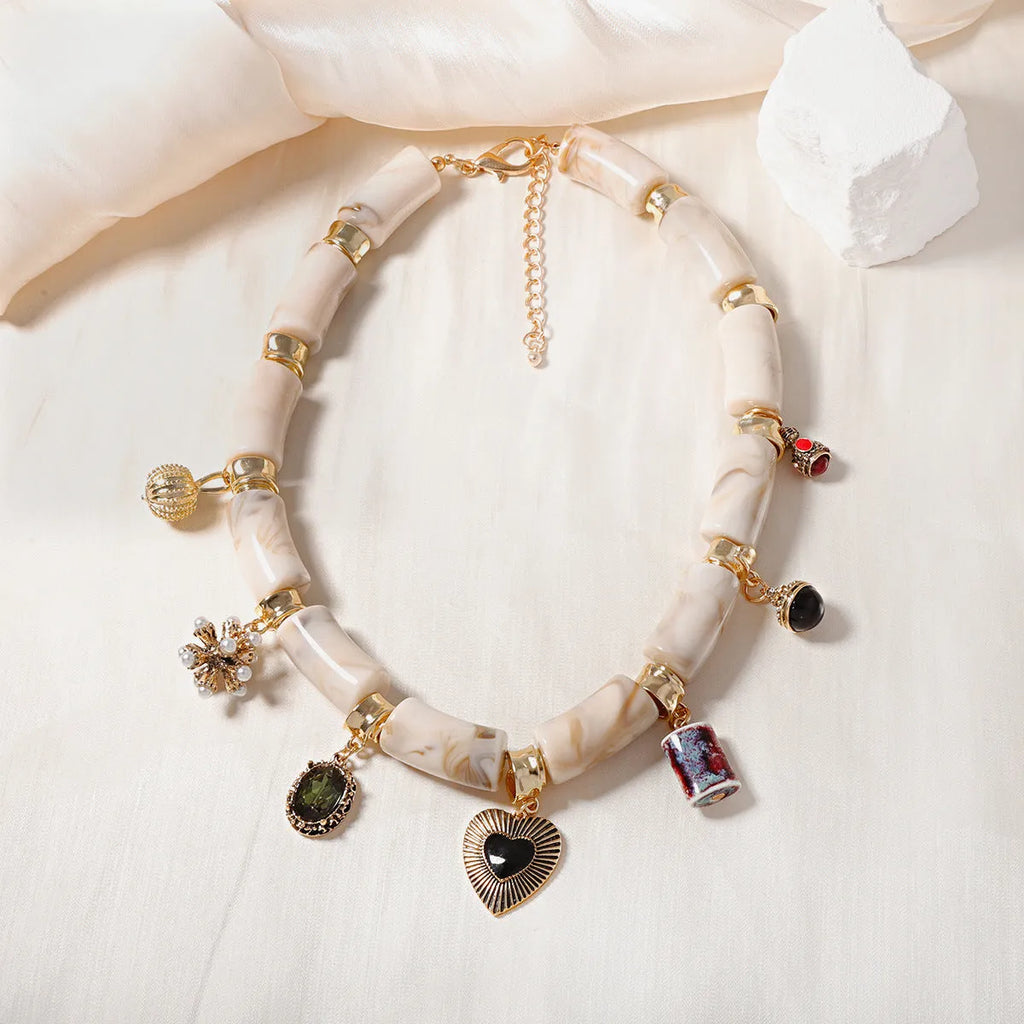 Bamboo-shaped resin pendant necklace with heart charm and electroplated finish.