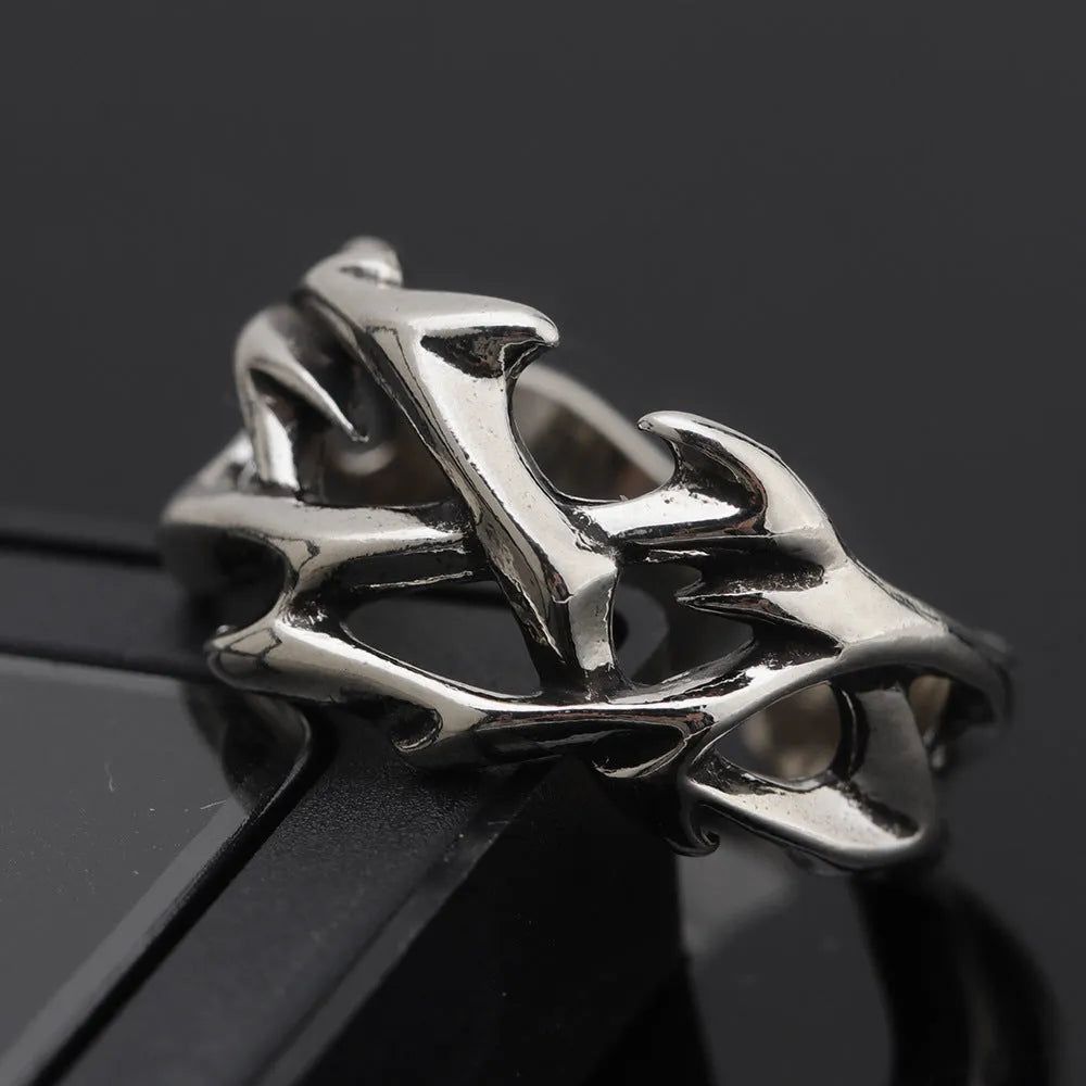 Copper geometric thorn and flower design ring with an adjustable opening on a dark background.