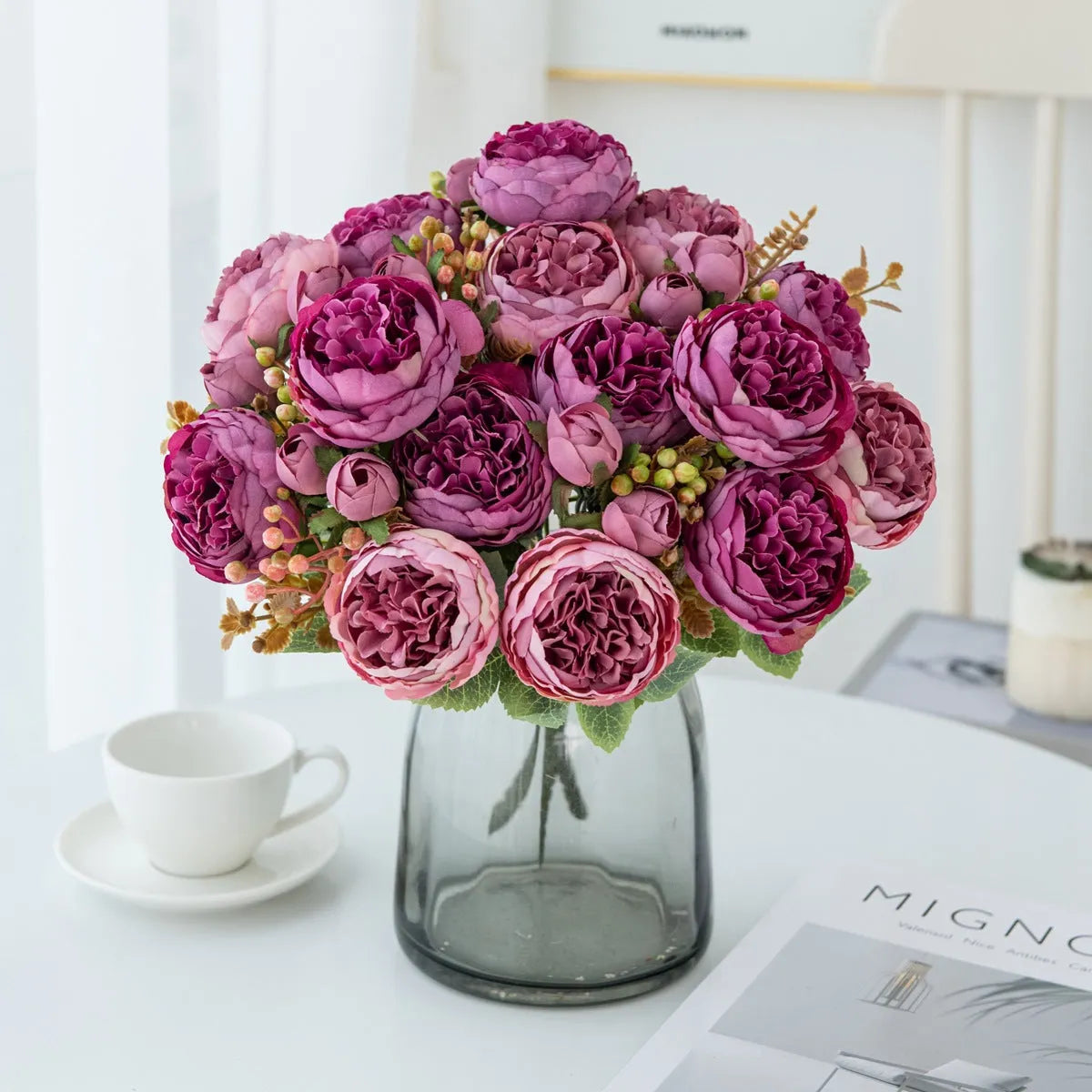 Artificial silk peony bouquet in a vase with champagne coloured blooms and green leaves