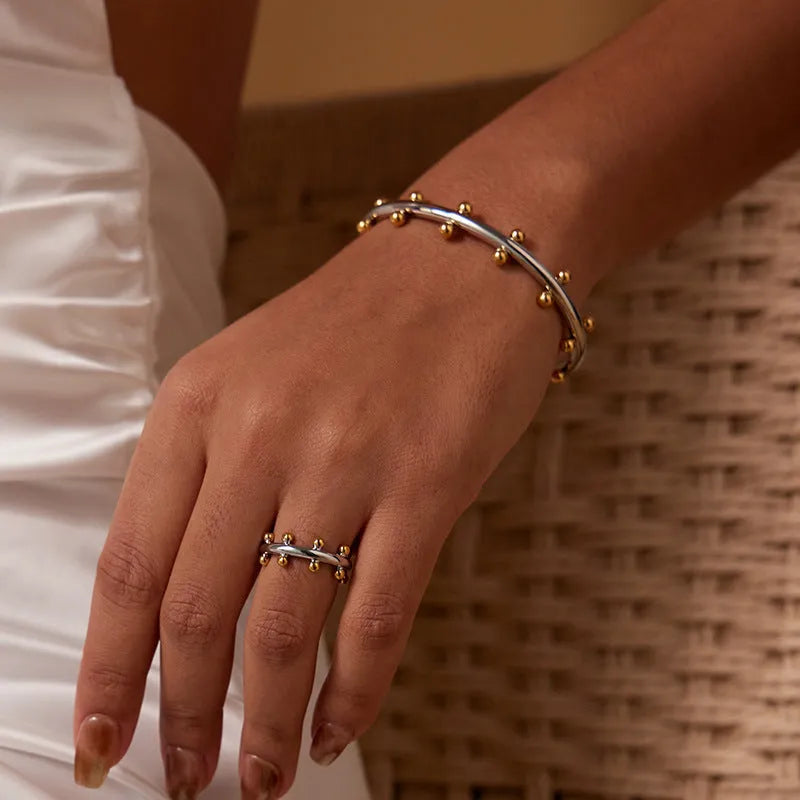 Stainless steel C-shaped bean bead with rivet texture in gold and steel colours for bracelet making.