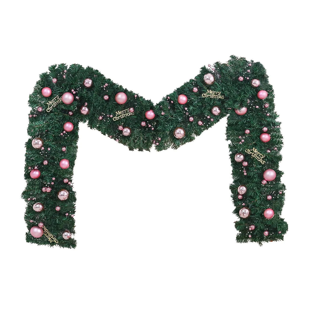 Long pink Christmas rattan garland with small decorative fruits and warm white LED lights draped on a mantelpiece.