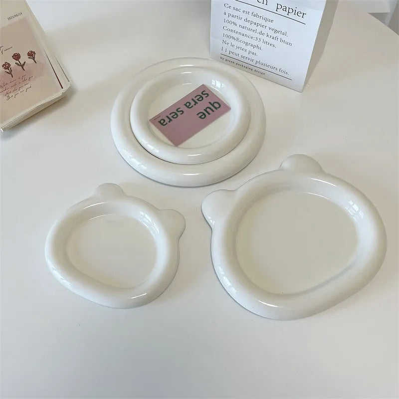 White porcelain plate with doodle design, shown in round and bear shapes, small and large sizes.