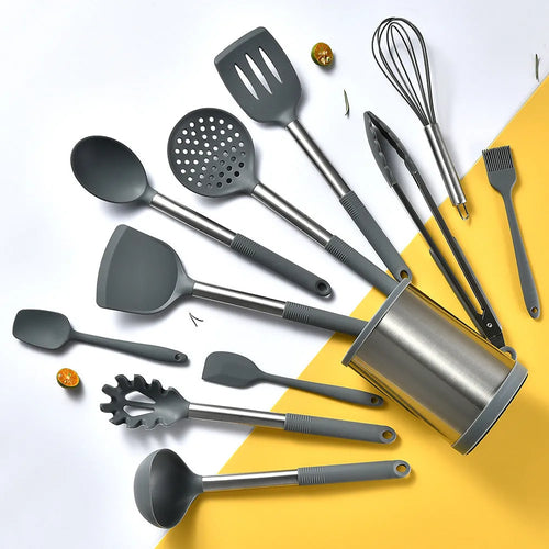 Silicone kitchen utensil set with twelve tools in a rotating white storage caddy on a counter.