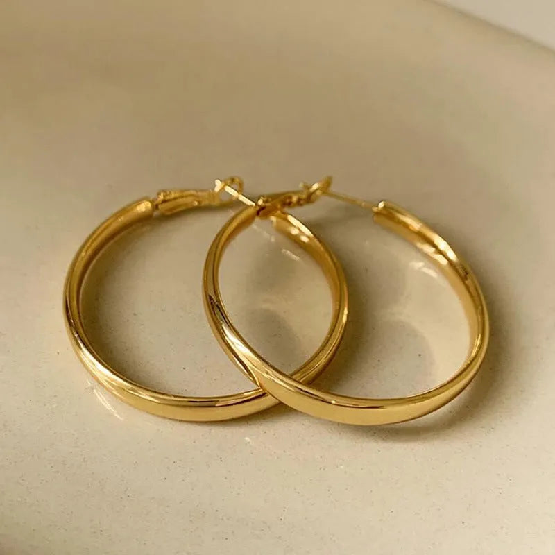 A pair of gold-coloured metal circle hoop earrings on a 40mm diameter.