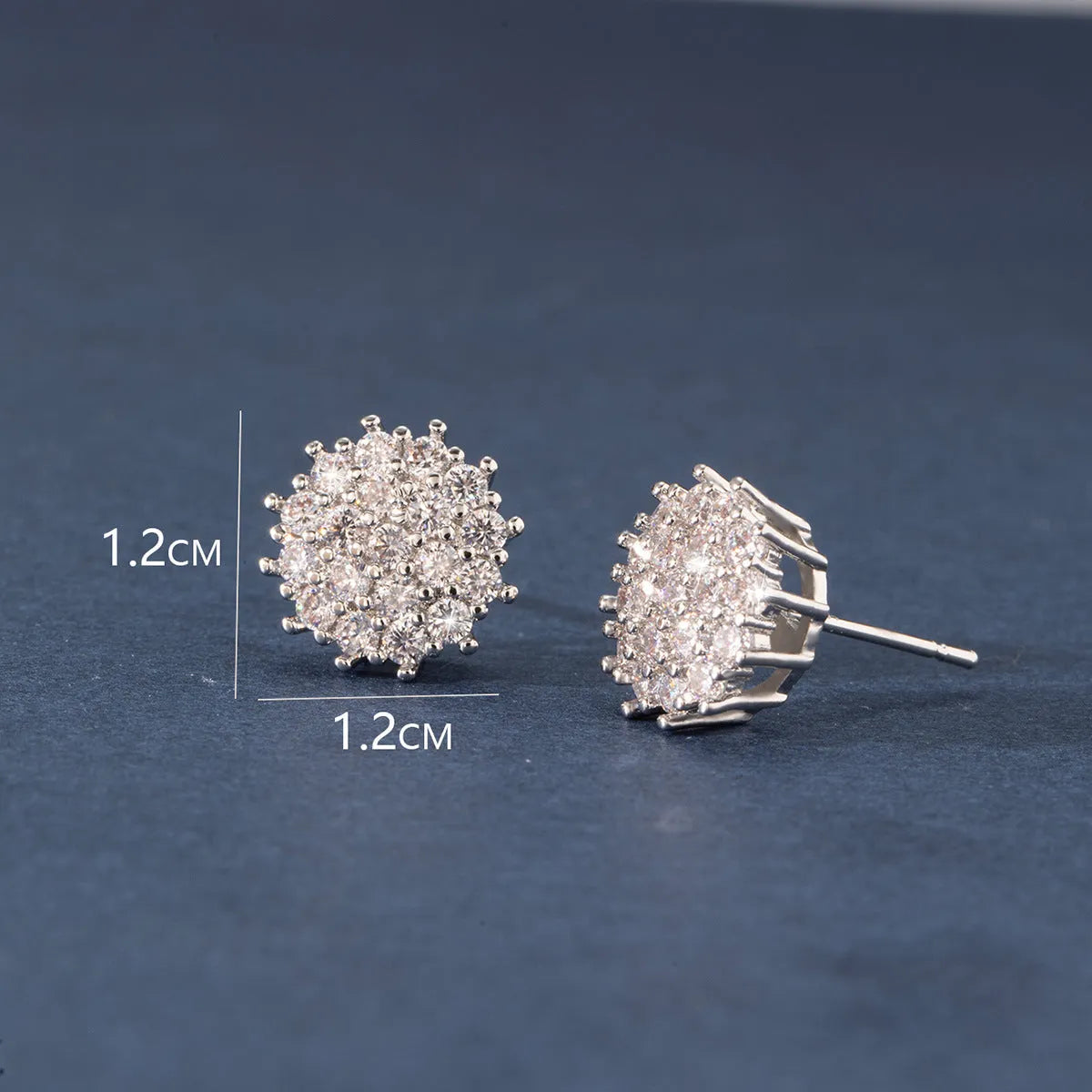 Pair of copper electroplated stud earrings in silver with irregular and round shapes on white background
