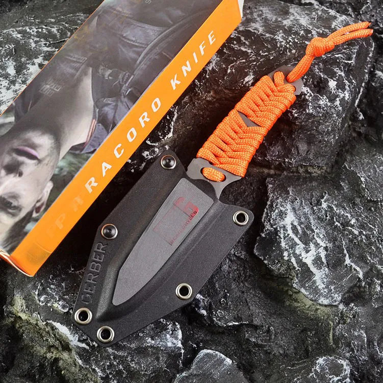 Straight camping survival knife with binding rope handle next to ABS sheath