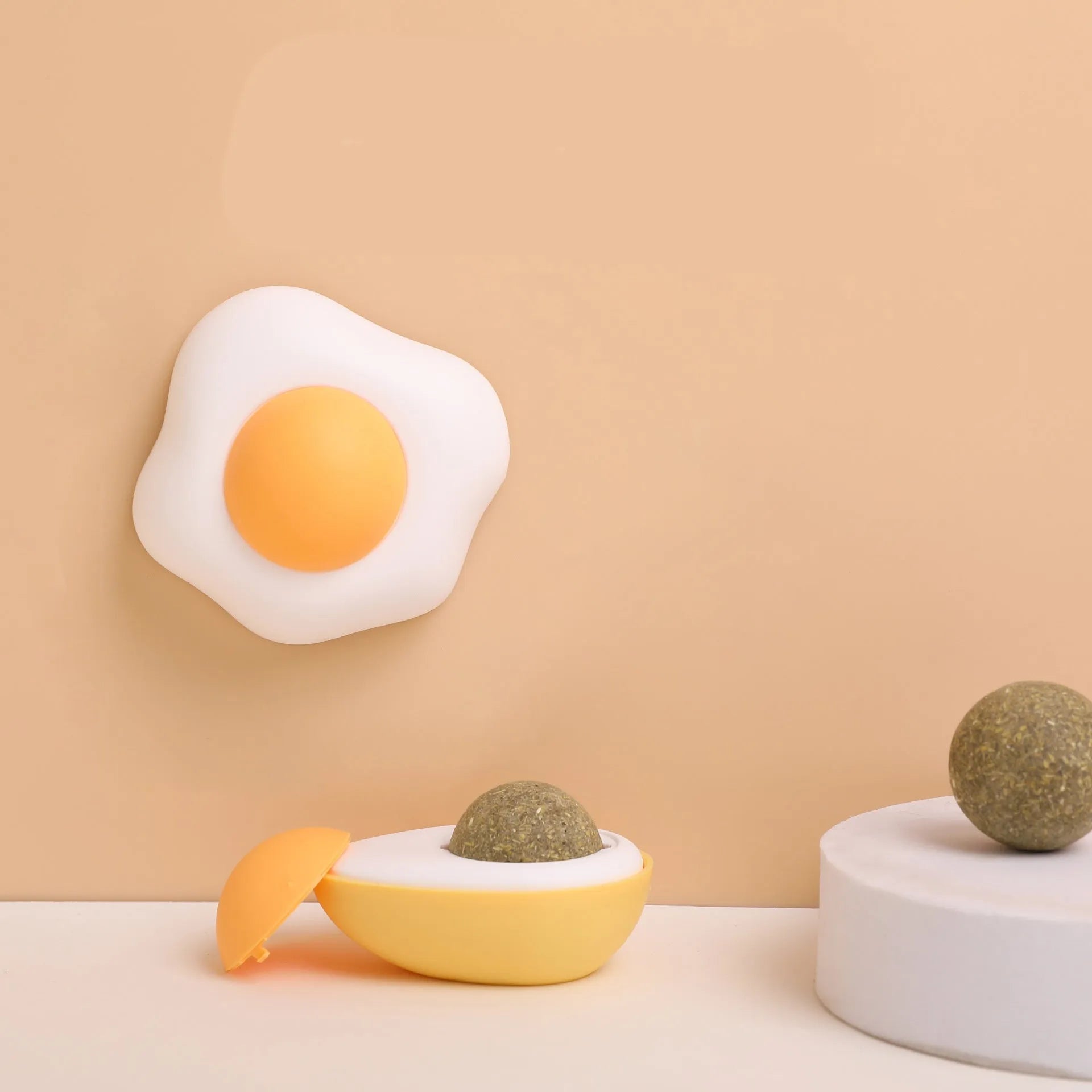 Interactive catnip ball toy with egg design mounted on wall for feline play