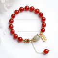 Gold-plated women's bracelet with red agate and Hetian jade beads in a traditional pattern.