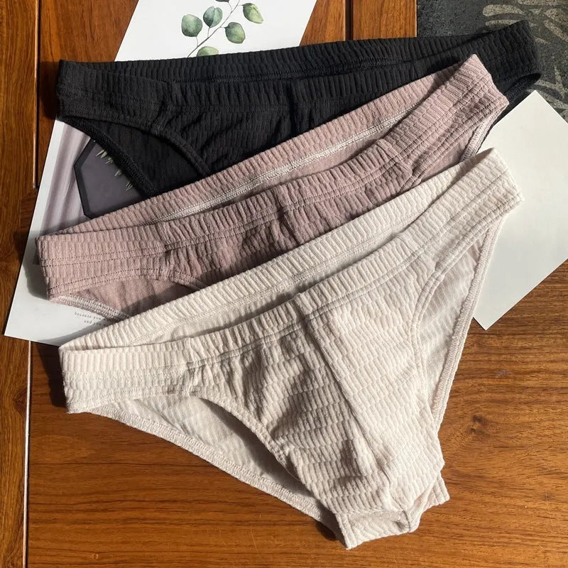 Men's triangle underwear briefs in solid colours showing cotton fabric texture and mid waist design