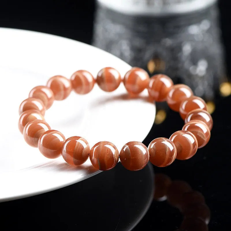 Natural Old Mine Rhodochrosite round bead bracelet on wrist, showing manganese spar colour.