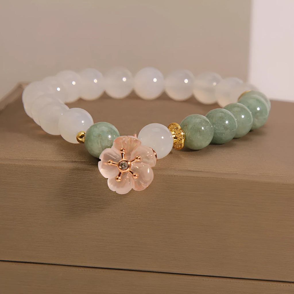 White agate jade flower bracelet with pink accent stones on wrist