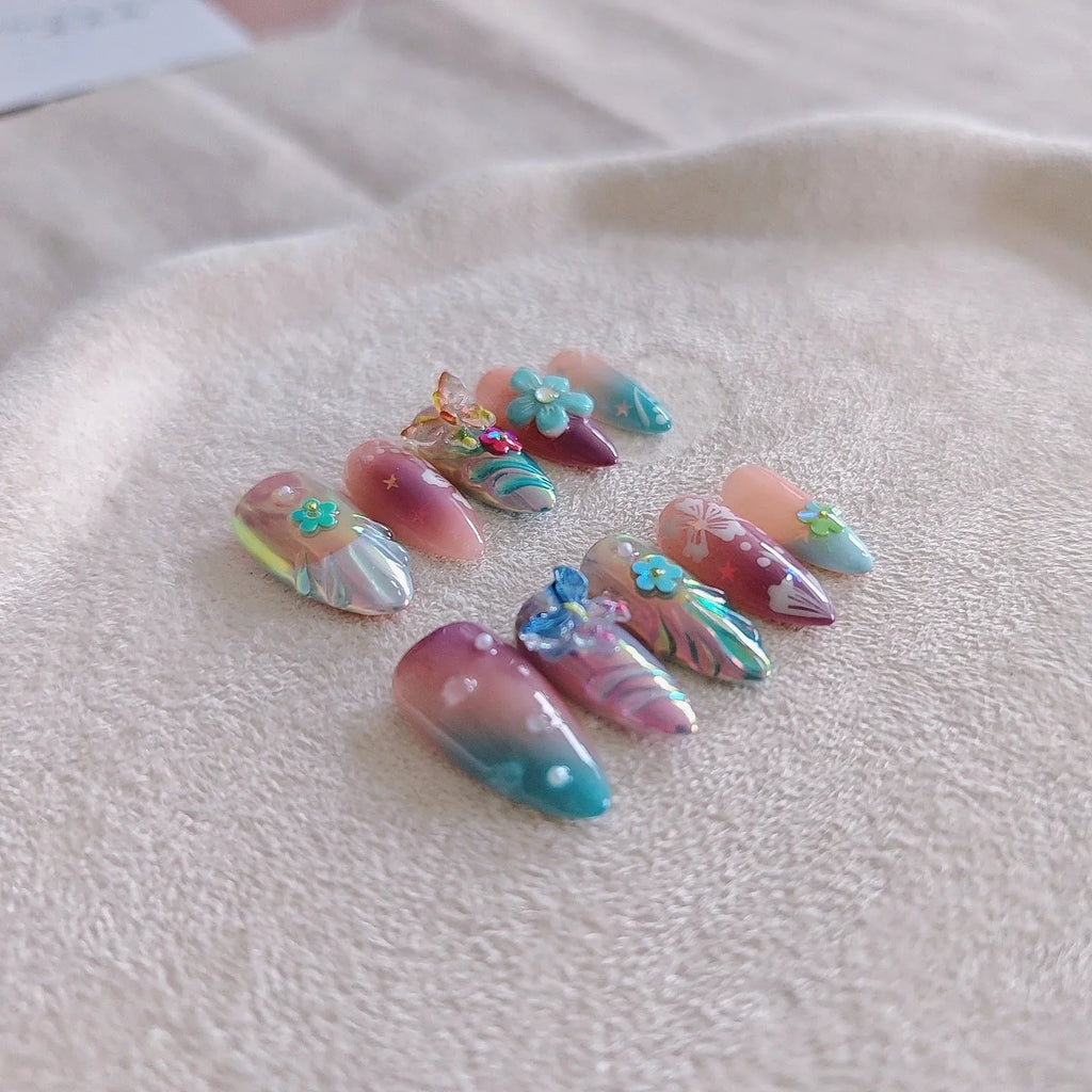 Handmade colourful embossed flower and butterfly nail art charms on a manicure set.
