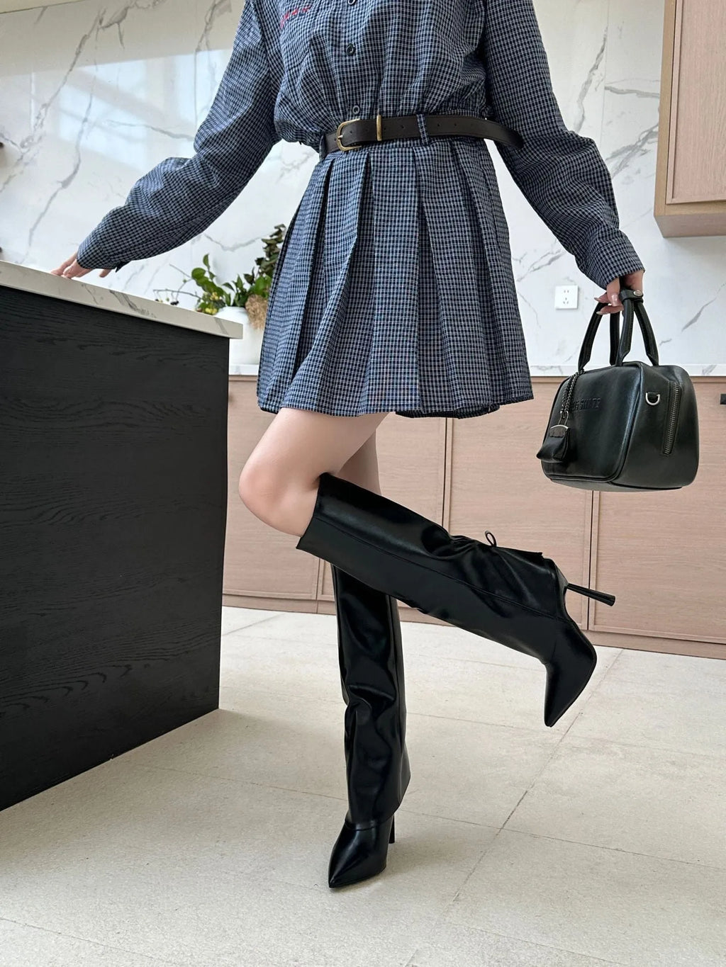 Black women's leg warmer boot covers with stiletto heel, pointed toe, and high cylinder length, shown as shoe oversleeves.