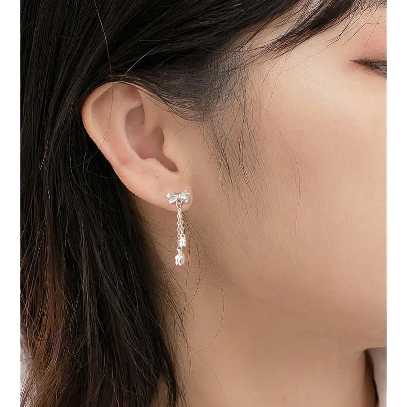 Silver bow ear studs with sweet tassel details and Korean style design for women
