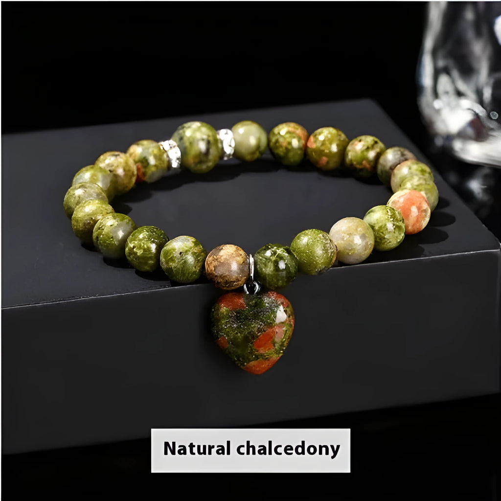 Handmade natural crystal love pendant bracelet with round beads in tiger's eye, aventurine, and white jade on a white background