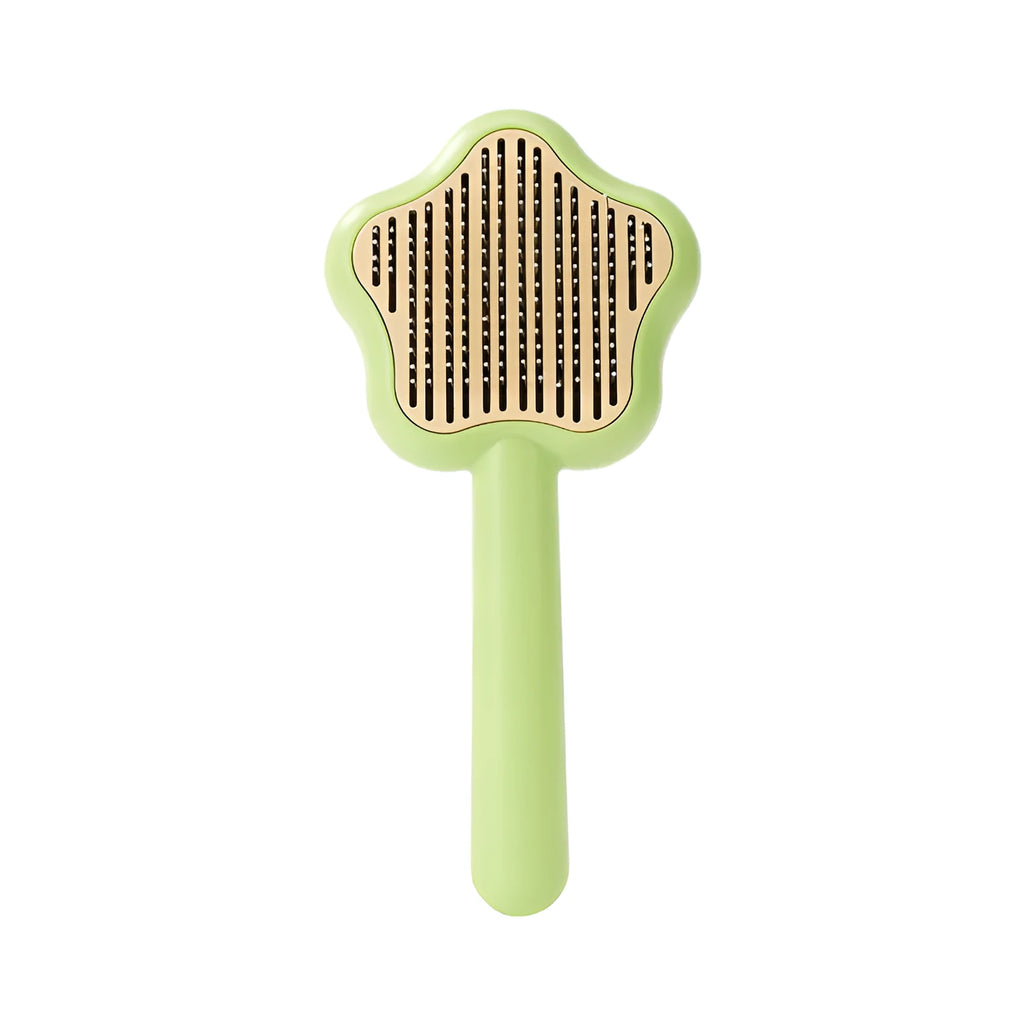 Green and yellow handled self-cleaning pet grooming comb with stainless steel needle bristles.