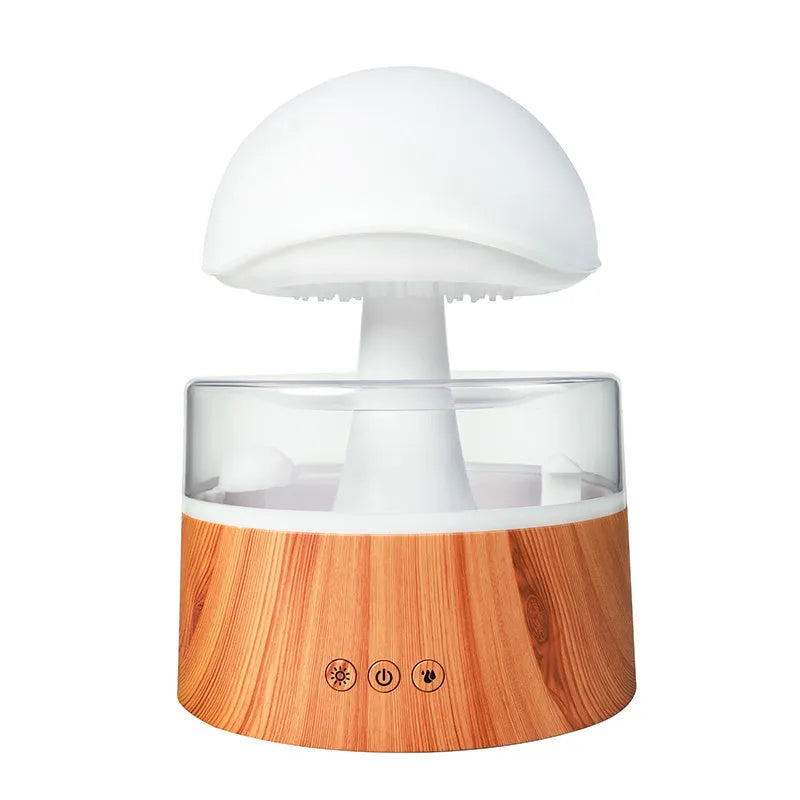 White plastic rain cloud humidifier with mist and coloured night light on a wooden surface