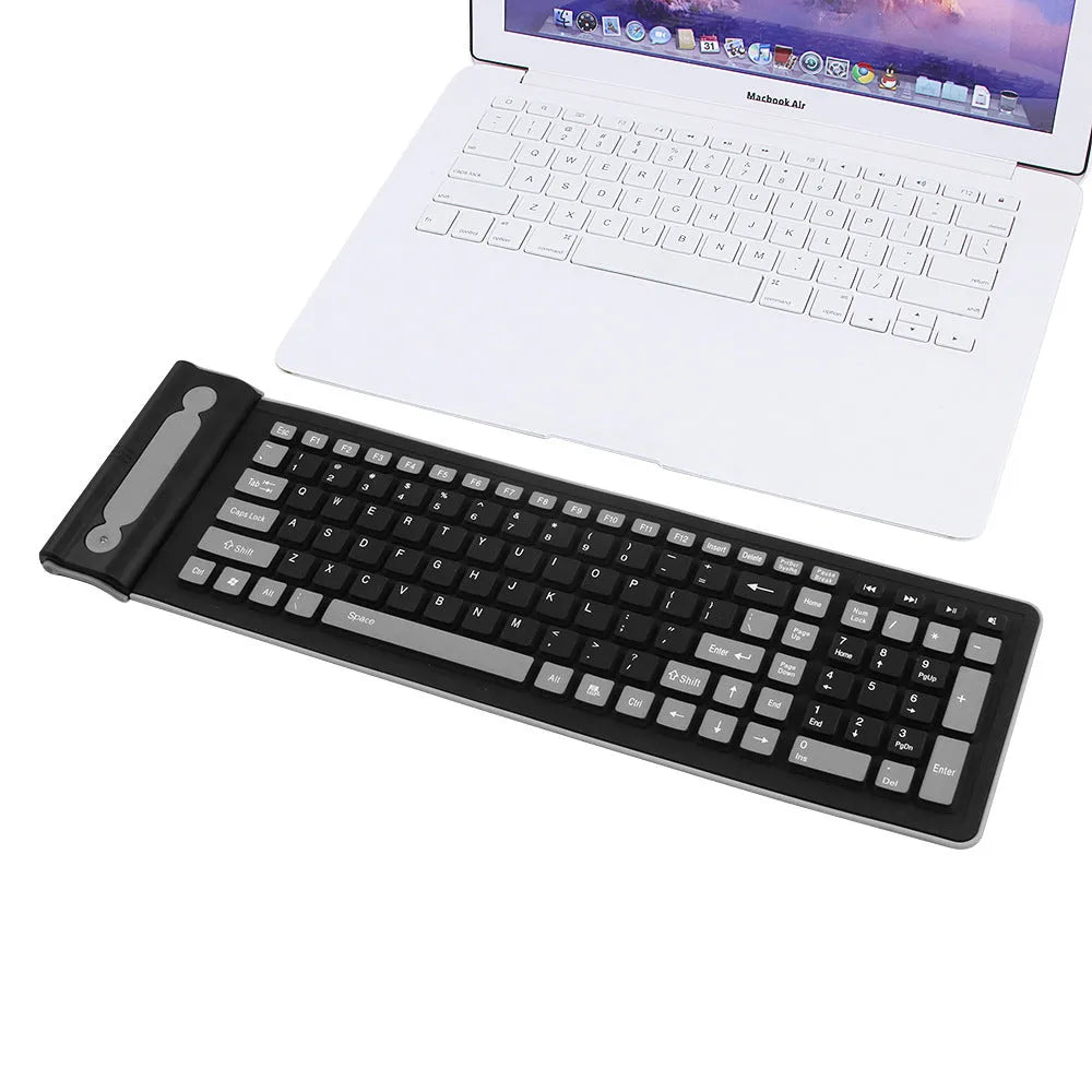 24g wireless mute folding silicone keyboard in folded position on a desk, showing USB receiver