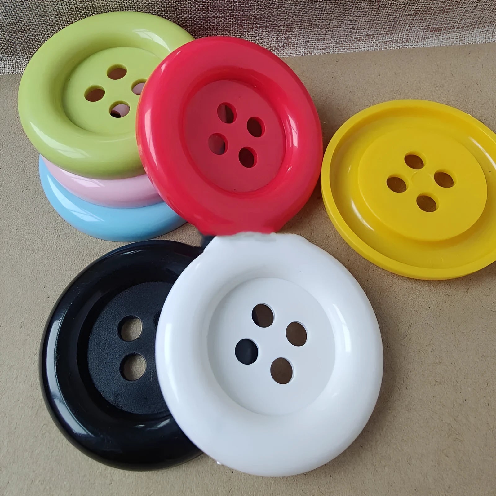 Oversized plastic round edge button with four holes in assorted colours and sizes