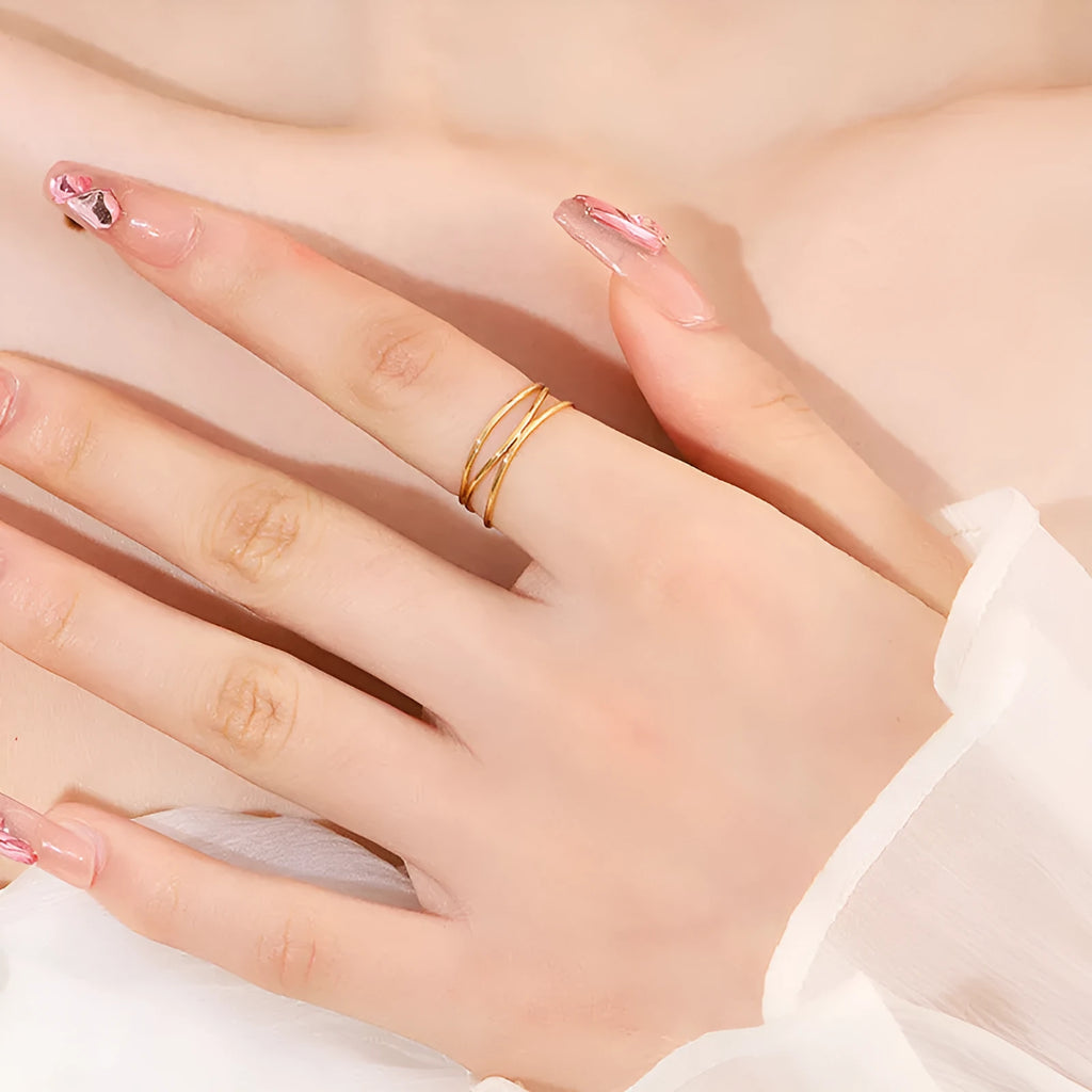 Gold titanium steel geometric ring with a three-layer coil design on a plain background.