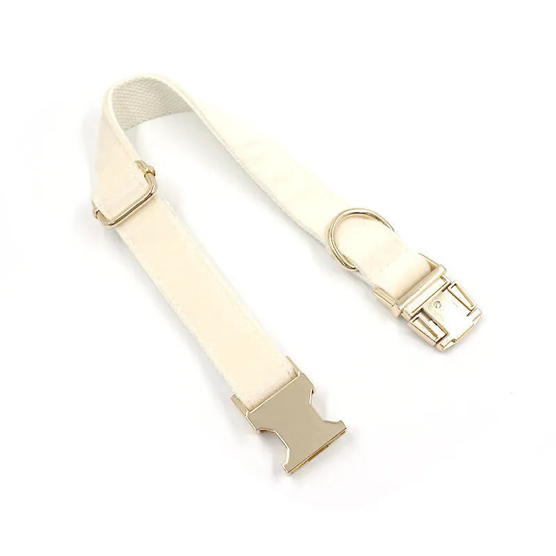Cream velvet dog collar with gold buckle, matching bow tie, and leash set on a white background
