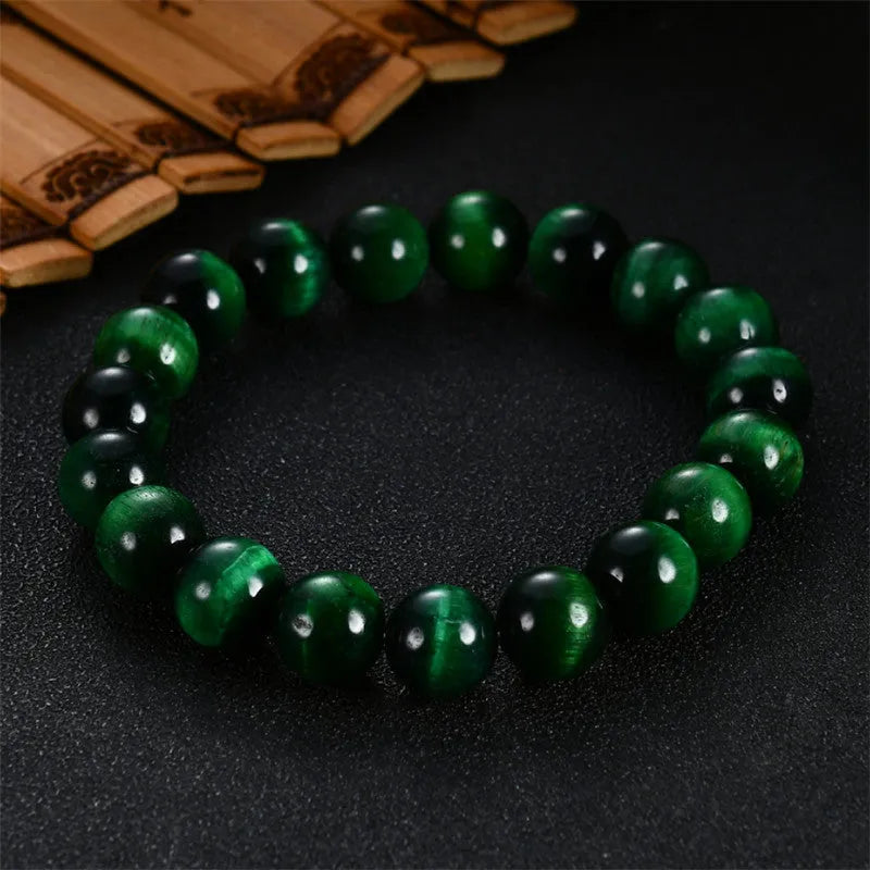 Green Tiger Eye stone bracelet with round polished beads on a wrist.