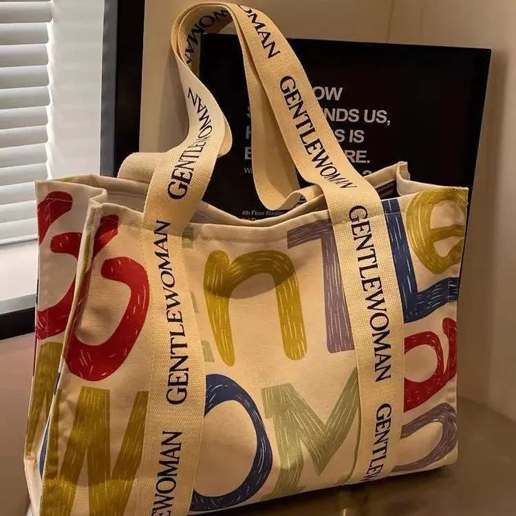 Large women's canvas tote bag with printed design, shown in available colour options.