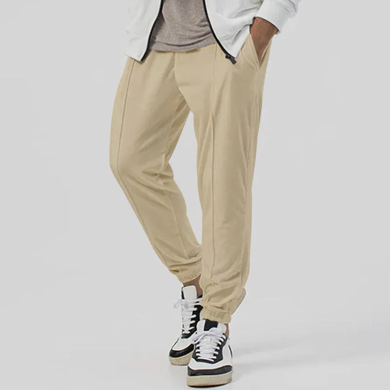 Men's grey straight-leg track sweatpants with a mid-waist, showcasing a relaxed fit and casual style.