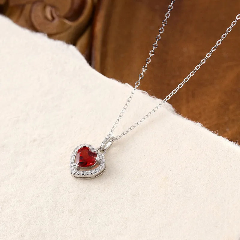 Women's sterling silver necklace with heart-shaped gemstone pendant on adjustable cross chain