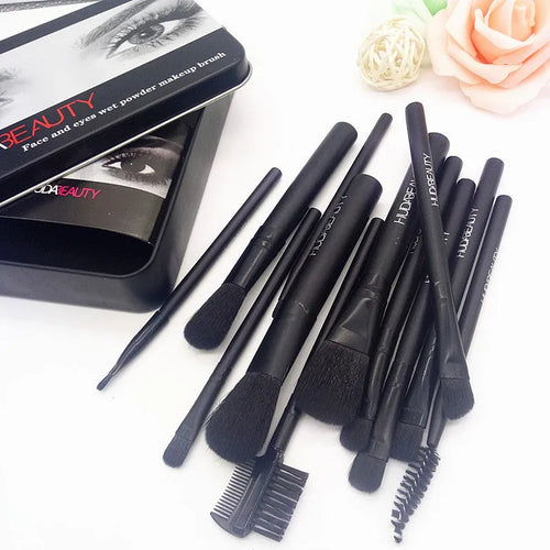 12 black makeup brushes in a tin box with nylon bristles and wooden handles on a white background