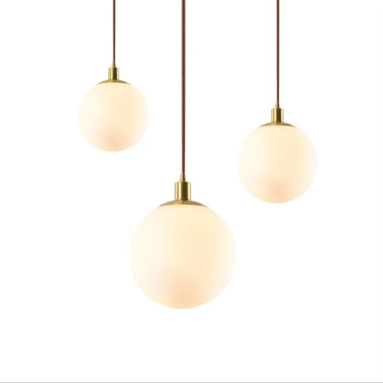 Nordic glass round spherical chandelier in milk white with copper fittings on a light background