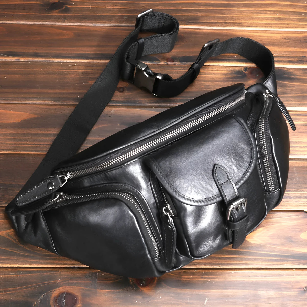 Black slanted chest bag in first layer cowhide with lock detail and polyester lining for daily commute