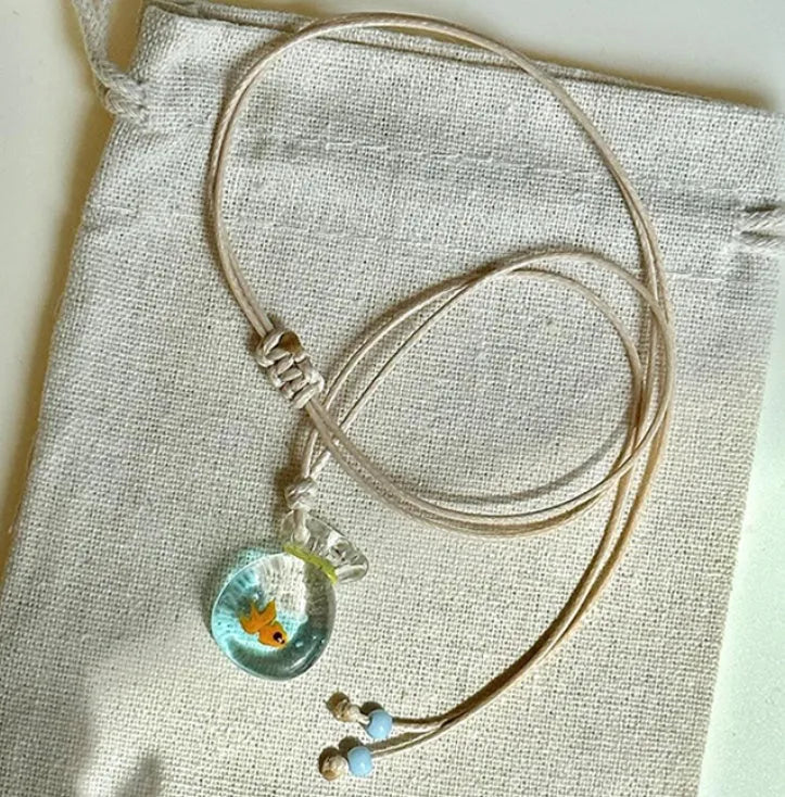 Women's necklace with a colourful skirt joker pendant on a long, braided cotton and linen chain.