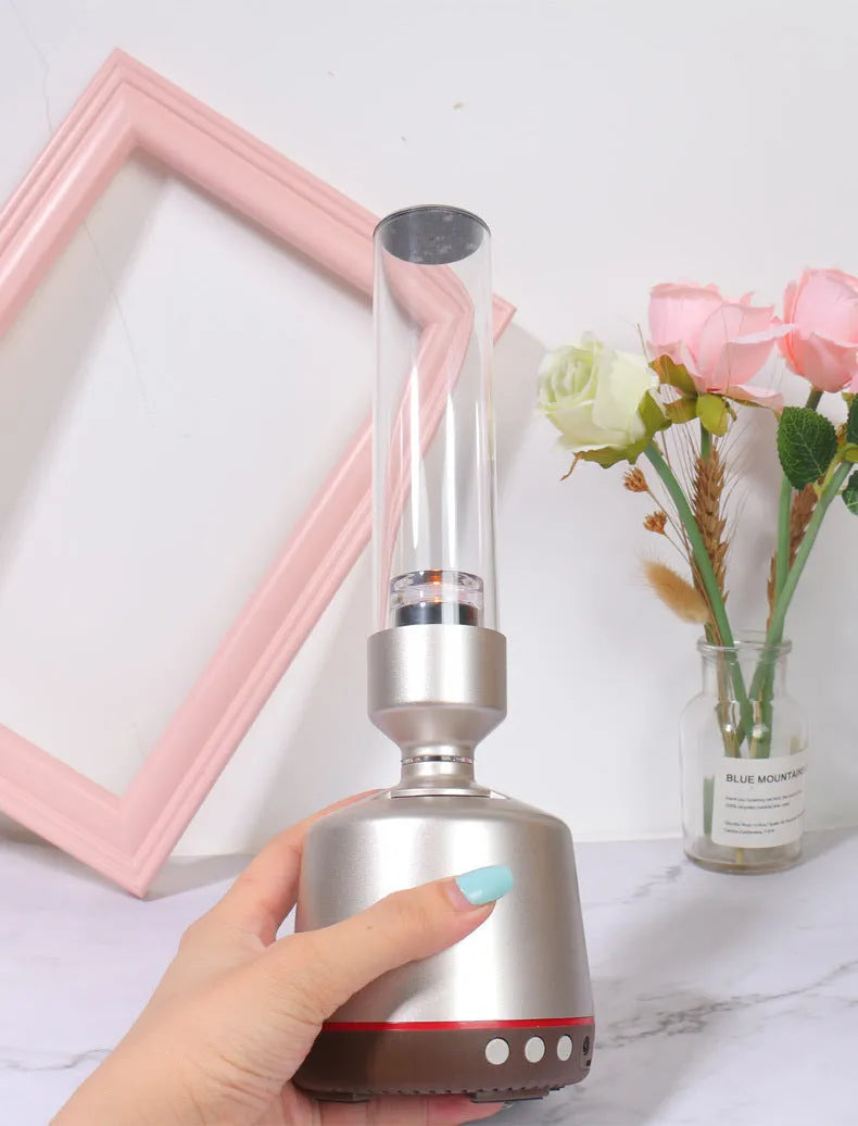 White silver Bluetooth speaker with candlelight night light effect, showing push buttons and compact design.