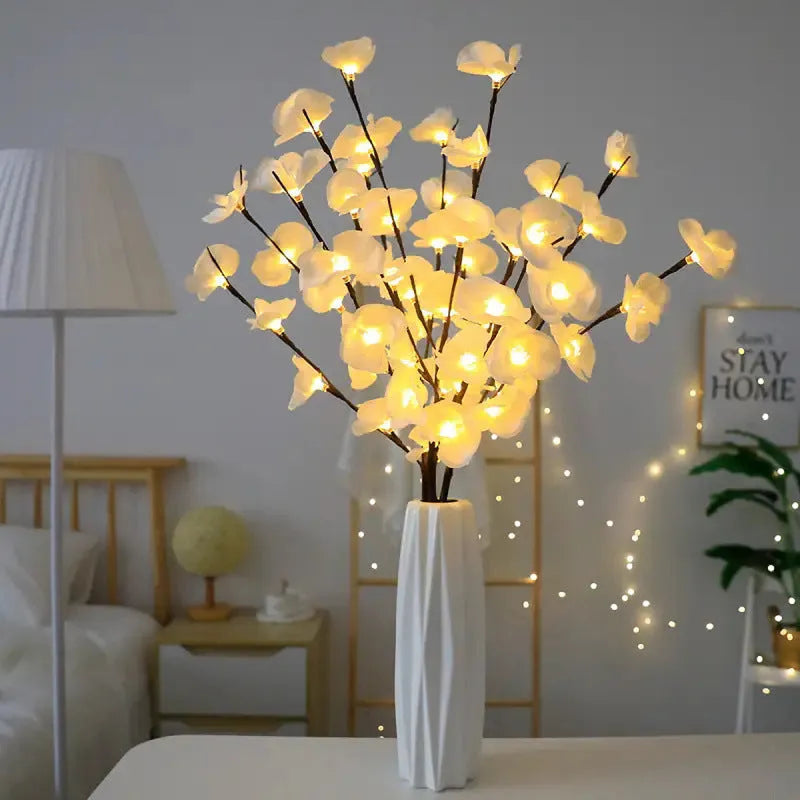 Pink phalaenopsis orchid branch decorative light with 20 LEDs, standing 65cm tall on a table.