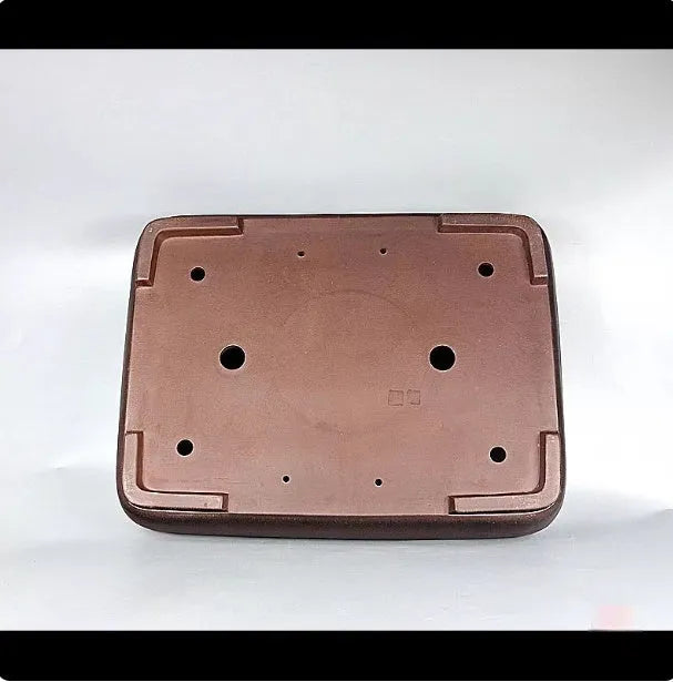 Large rectangular handmade antique purple clay flower pot on a table.