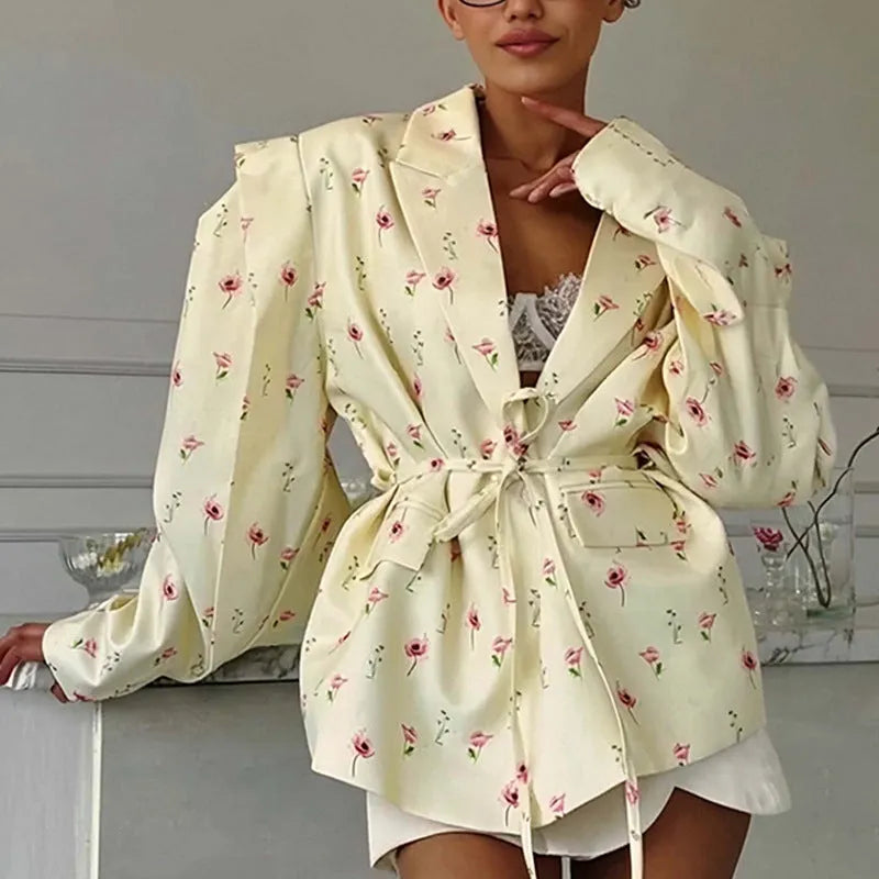 White suit jacket with a lace-up collar and a fitted waist on a model.
