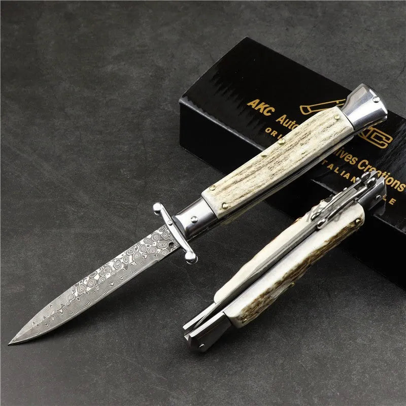 Damascus folding knife with 9.8cm blade and snake wood handle on outdoor wood surface