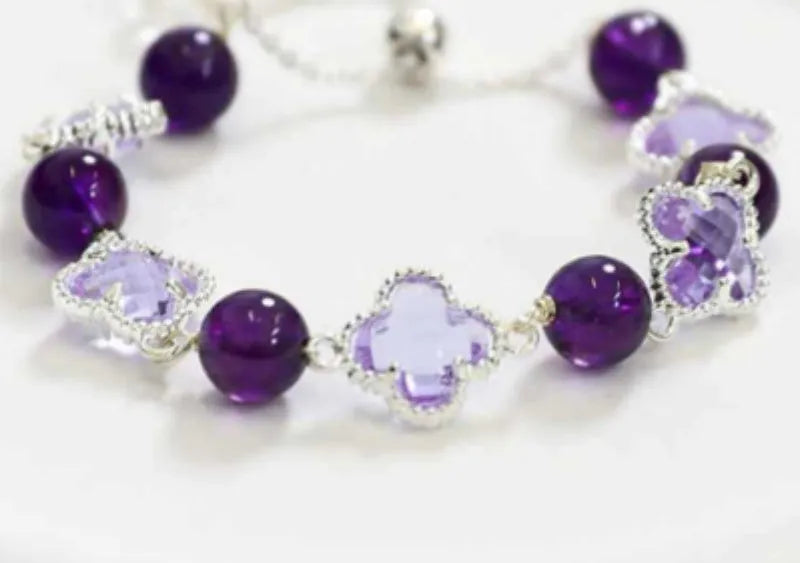 Women's artificial amethyst bracelet with four-leaf clover pendant and pearl accents on a U-shaped cuff.