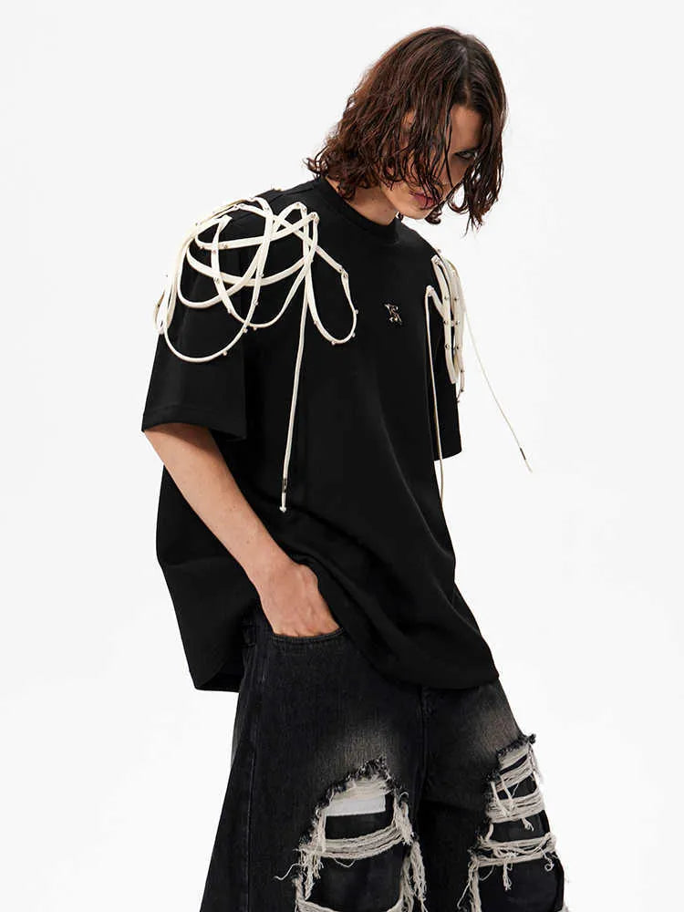 Black loose fit short sleeve t-shirt with padded shoulders and decorative rivet ribbon detail.