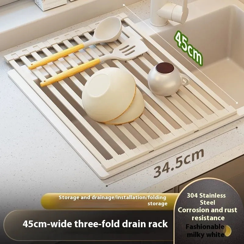 Milky White foldable stainless steel kitchen draining rack shown beside a sink, demonstrating its tri-fold mechanism.